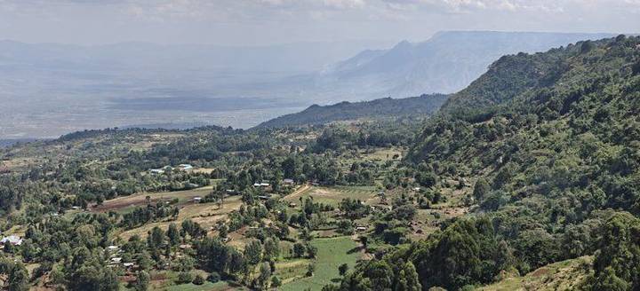 Vista desde el escarpe sobre el valle, con colinas verdes y campos de cultivo.