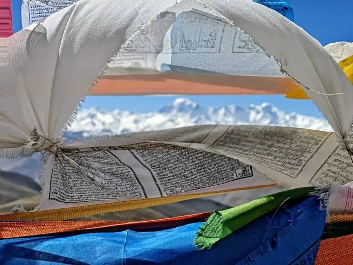 Banderas de oración al viento, con los gigantes del Himalaya en el horizonte.