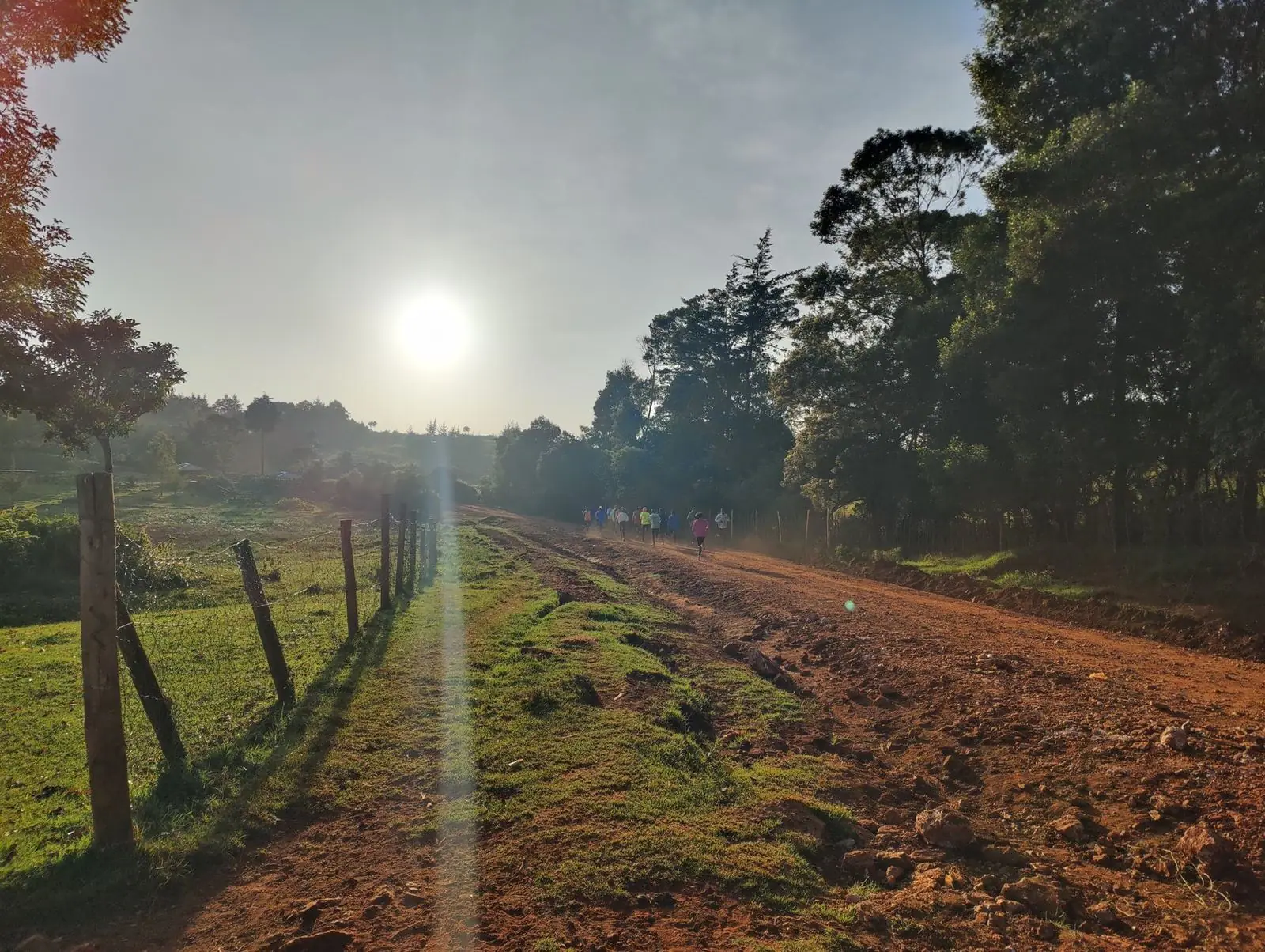 Amanecer en un camino de tierra roja: los primeros corredores del día ya están entrenando.